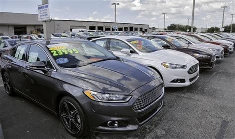 Budget used cars displayed at a small dealership lot
