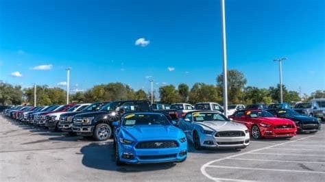 Used car dealership lot with summer clearance signage