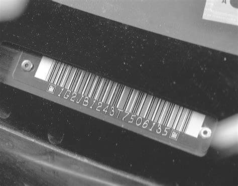 VIN plate visible through windshield on a vehicle dashboard