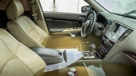 Flood-damaged car interior with wet seats and waterline staining