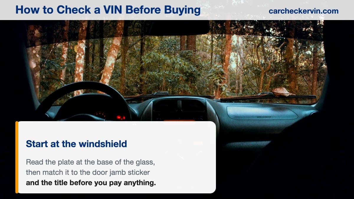 The driver's side of a car cabin, looking out over the dashboard towards the base of the windshield where the VIN plate sits