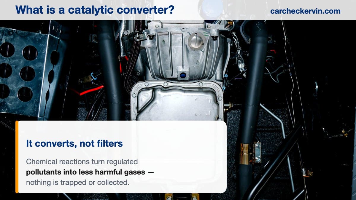 The exhaust system beneath a vehicle on a lift, where the catalytic converter sits